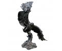 Escultura de águila con alas abiertas lateralmente sobre rama