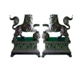 Pareja de leones chinos posados con bola y sobre peana realizado en bronce