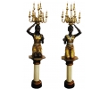 Pair of faux gilt bronze resin blackamoor torchierers holding candelabra