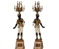 Pair of faux gilt bronze resin blackamoor torchierers holding candelabra