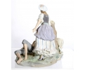 Escultura de porcelana Lladró que representa a una mujer inclinada sobre un hombre dormido con perro.