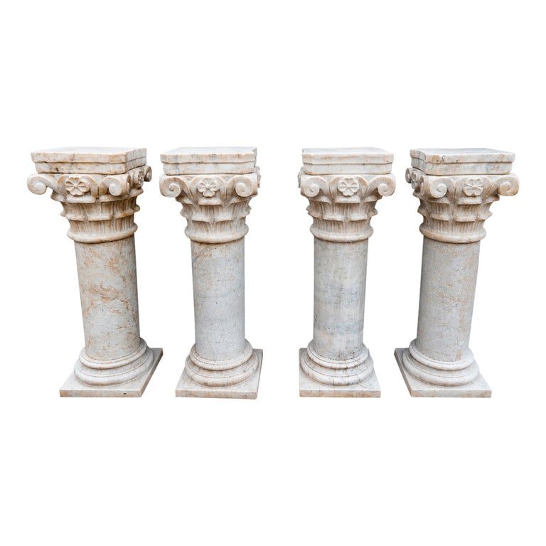 Conjunto de cuatro peanas de mármol con capiteles ornamentados