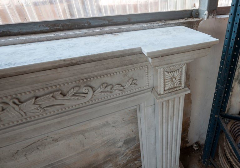 Chimenea clásica tallada en mármol blanco de estilo neoclásico