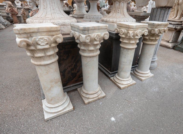 Conjunto de cuatro peanas de mármol con capiteles ornamentados