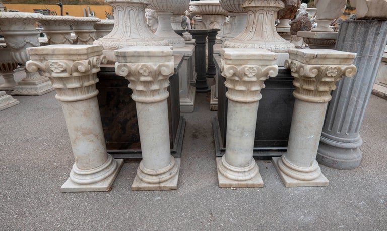 Conjunto de cuatro peanas de mármol con capiteles ornamentados