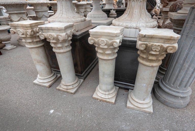 Conjunto de cuatro peanas de mármol con capiteles ornamentados