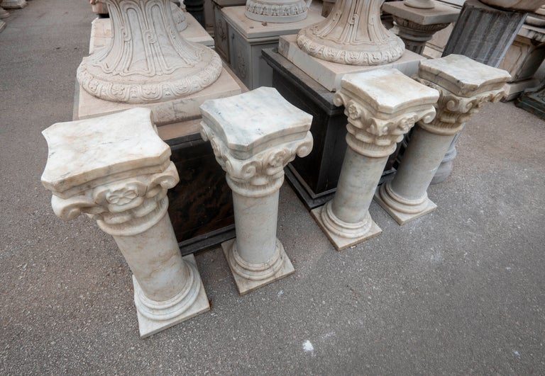 Conjunto de cuatro peanas de mármol con capiteles ornamentados