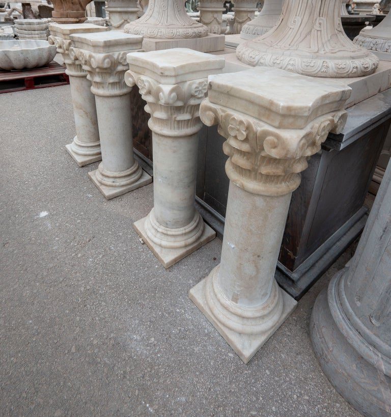 Conjunto de cuatro peanas de mármol con capiteles ornamentados
