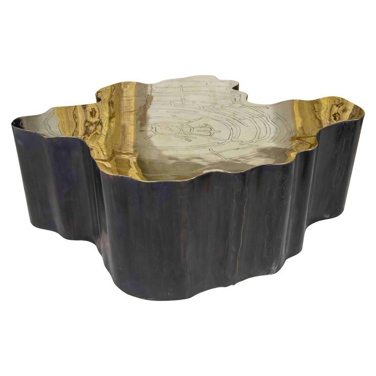 Mesa de centro escultural de metal con tapa de latón grabado
