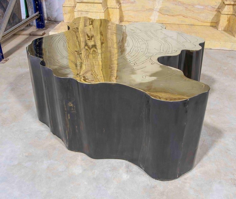 Mesa de centro escultural de metal con tapa de latón grabado