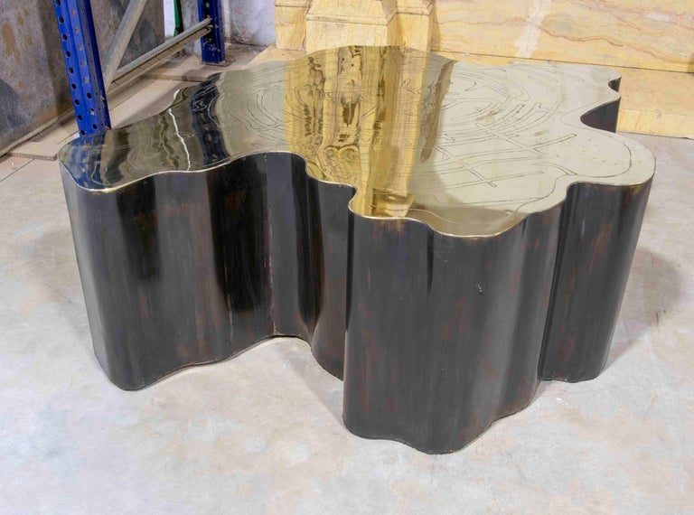Mesa de centro escultural de metal con tapa de latón grabado