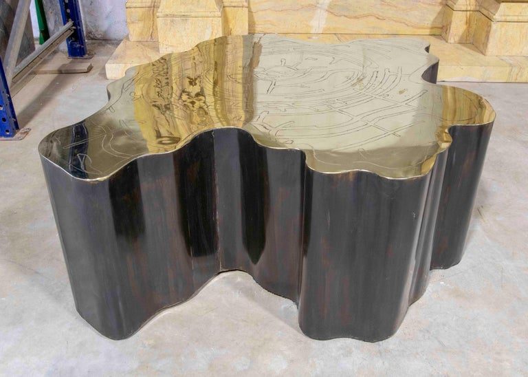 Mesa de centro escultural de metal con tapa de latón grabado