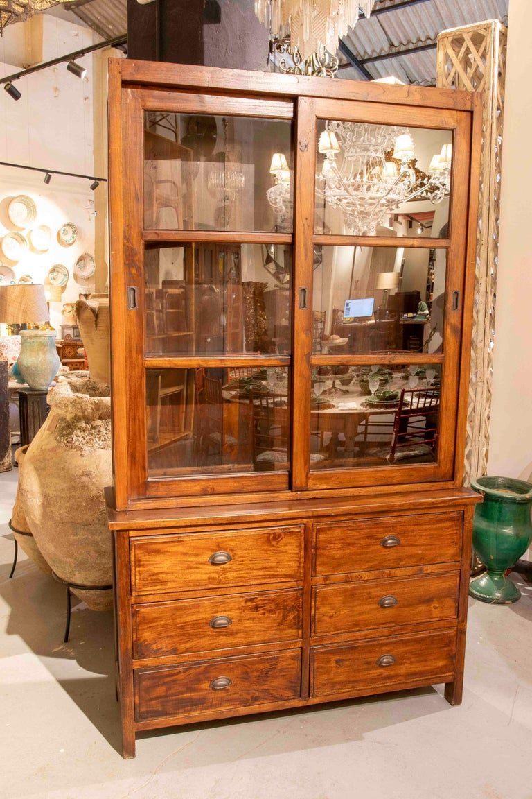 Vitrina antigua de madera de los años 50 con puertas correderas y seis cajones