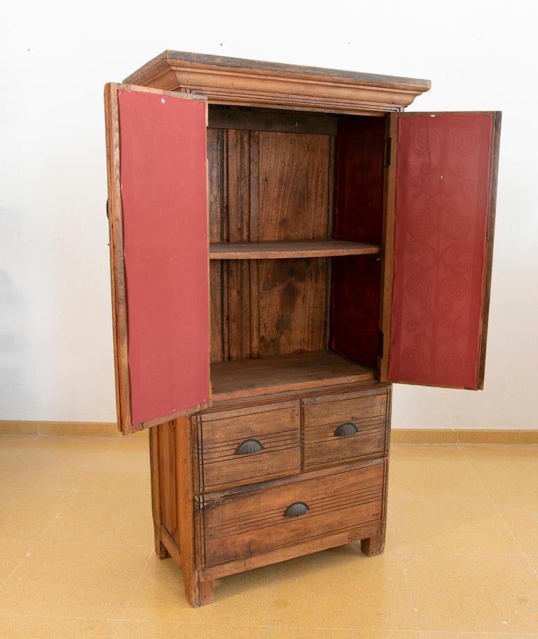 Armario de madera con puertas decoradas con hierro y tres cajones