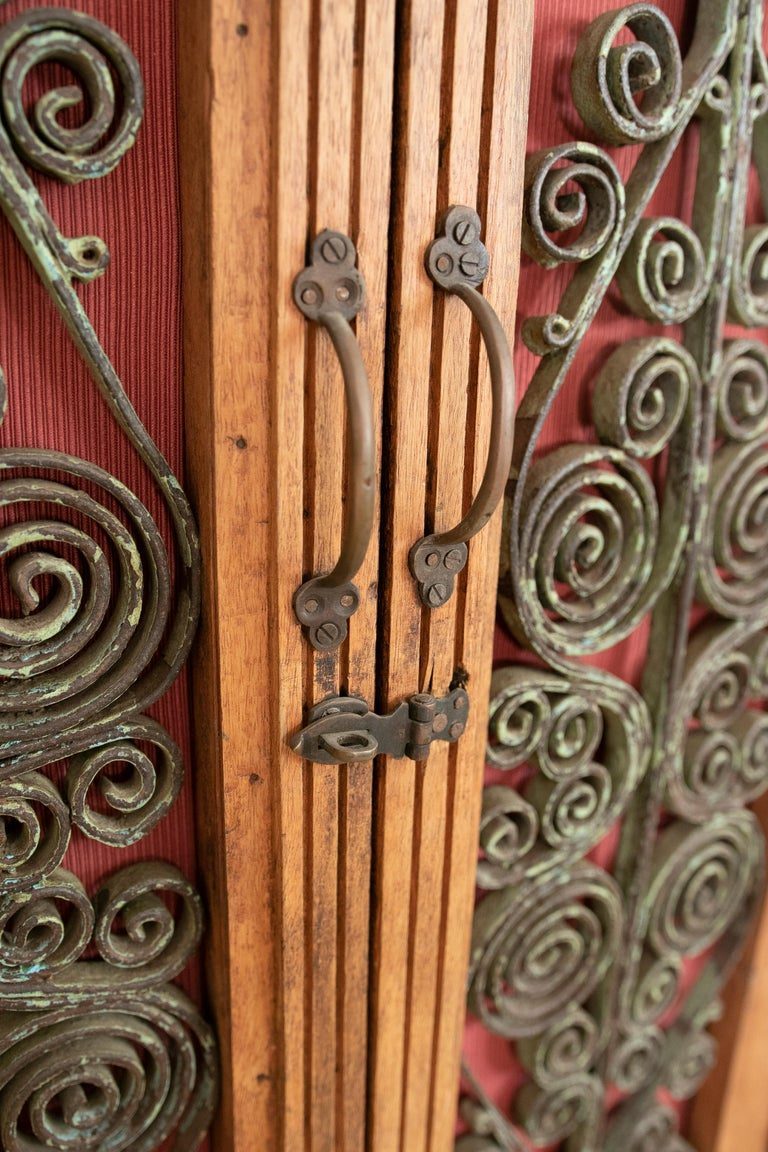 Armario de madera con puertas decoradas con hierro y tres cajones