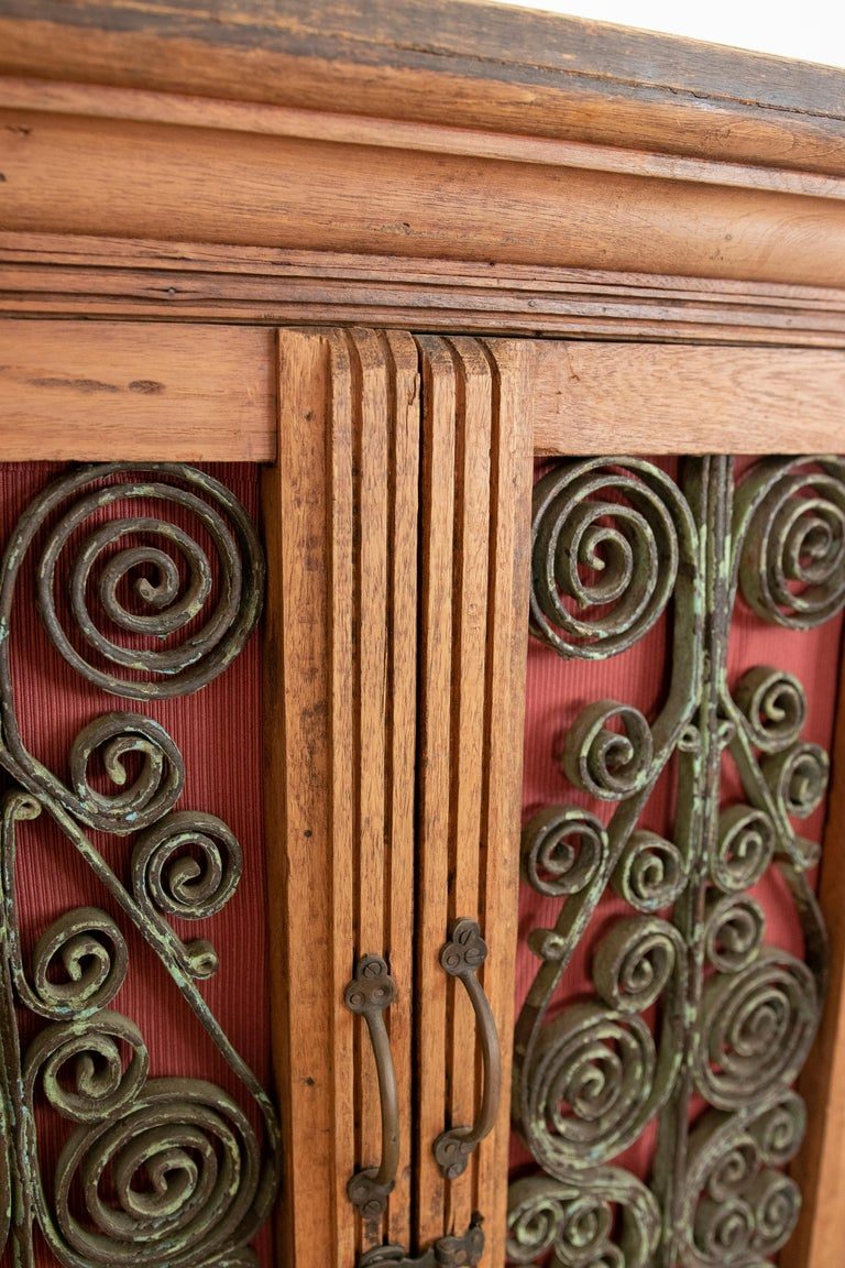 Armario de madera con puertas decoradas con hierro y tres cajones