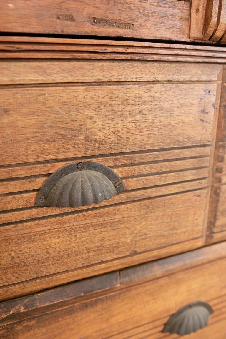 Armario de madera con puertas decoradas con hierro y tres cajones