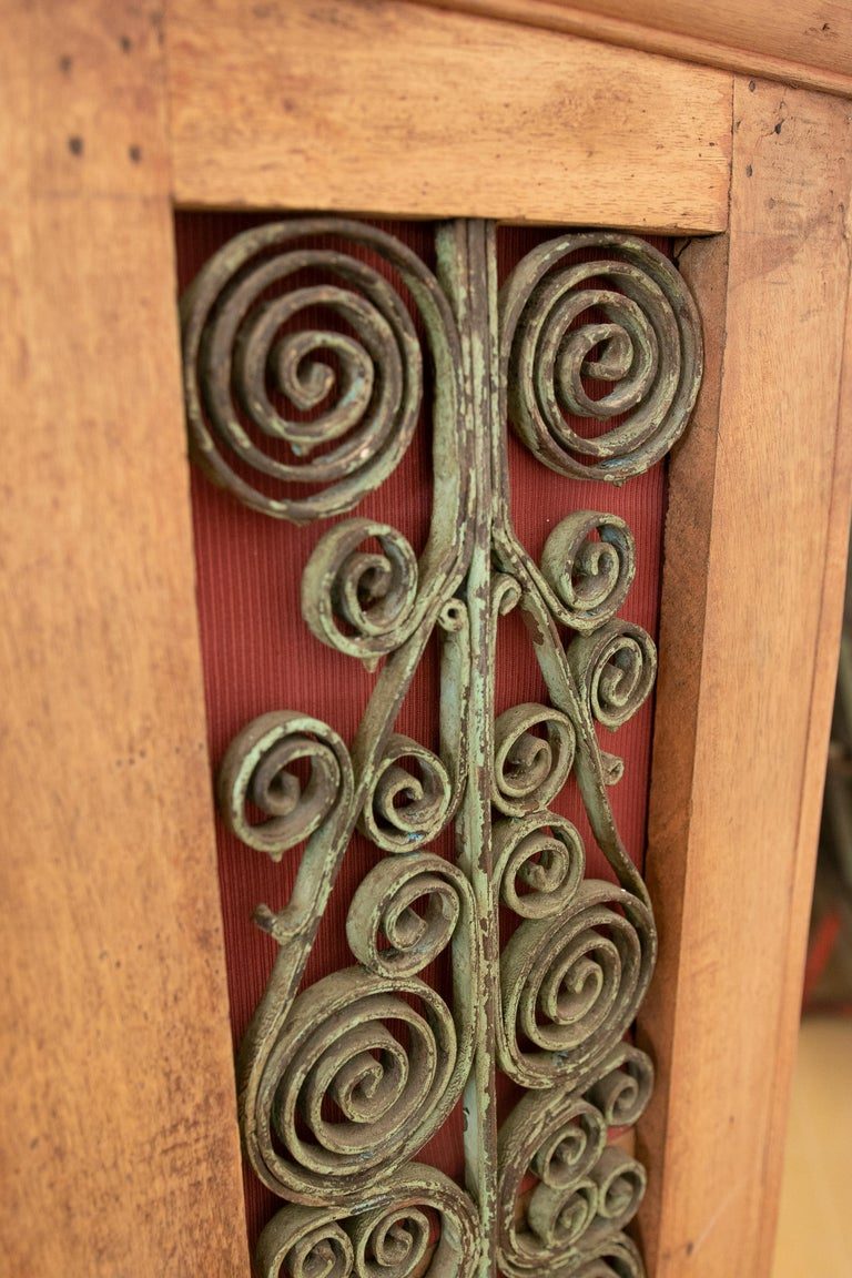 Armario de madera con puertas decoradas con hierro y tres cajones