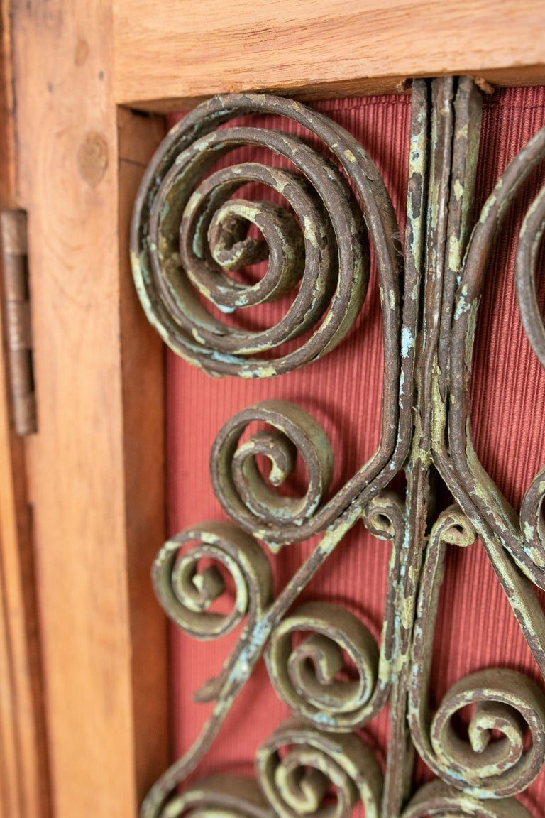Armario de madera con puertas decoradas con hierro y tres cajones