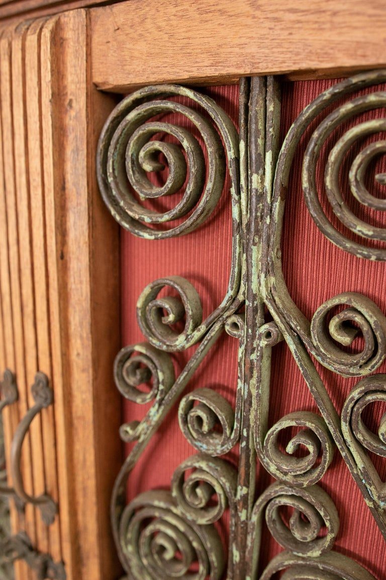 Armario de madera con puertas decoradas con hierro y tres cajones