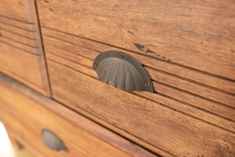 Armario de madera con puertas decoradas con hierro y tres cajones