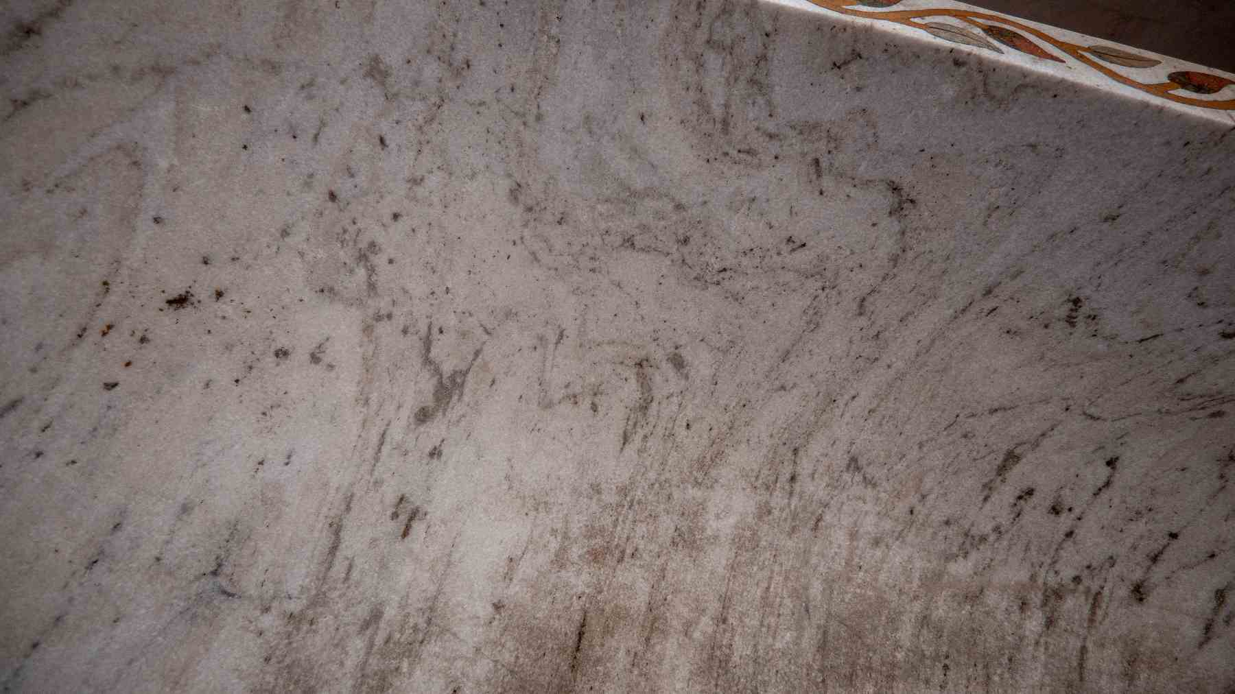 Bañera hexagonal de mármol tallado con incrustaciones de piedras duras