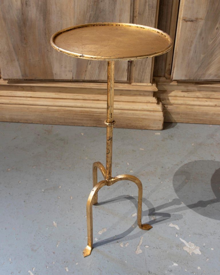Mesa auxiliar redonda de hierro dorado con soporte