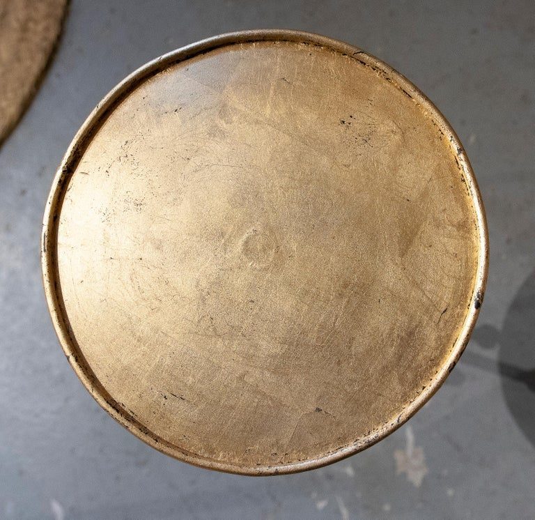 Mesa auxiliar redonda de hierro dorado con soporte